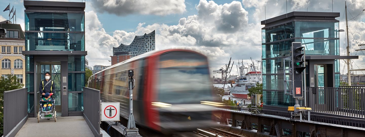 Zwischen den Aufzügen an den Bahnsteigen der Haltestelle Landungsbrücken fährt eine U-Bahn vorbei